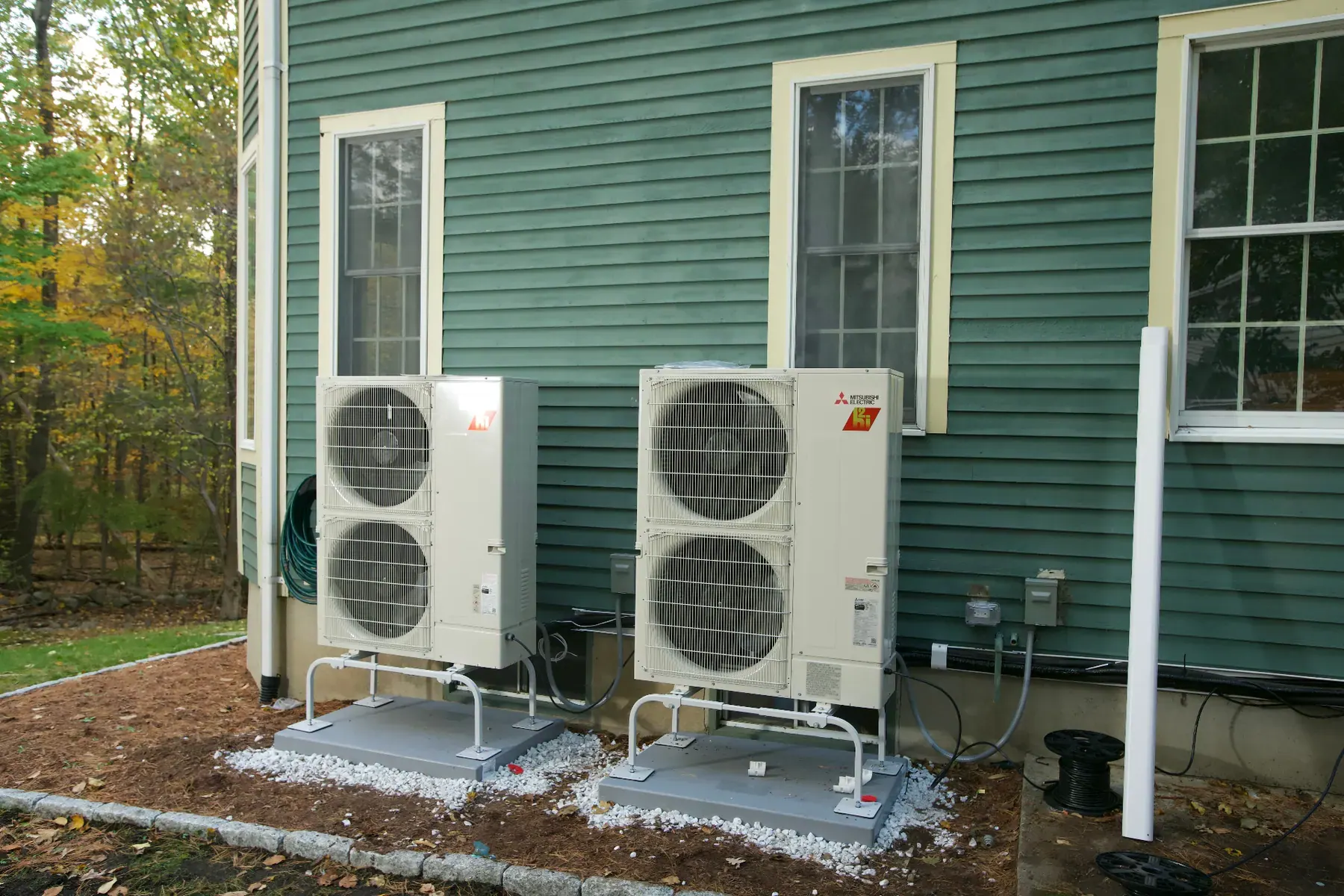 New Mitsubishi central air condensers installed beside a home