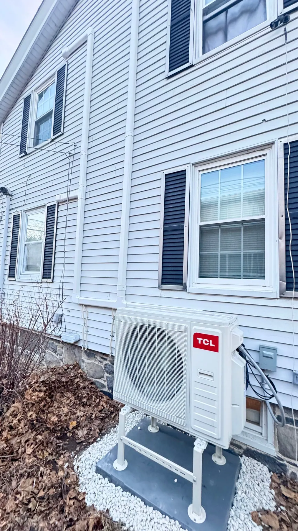 TCL mini split outdoor condenser installed on the side of a Massachusetts home