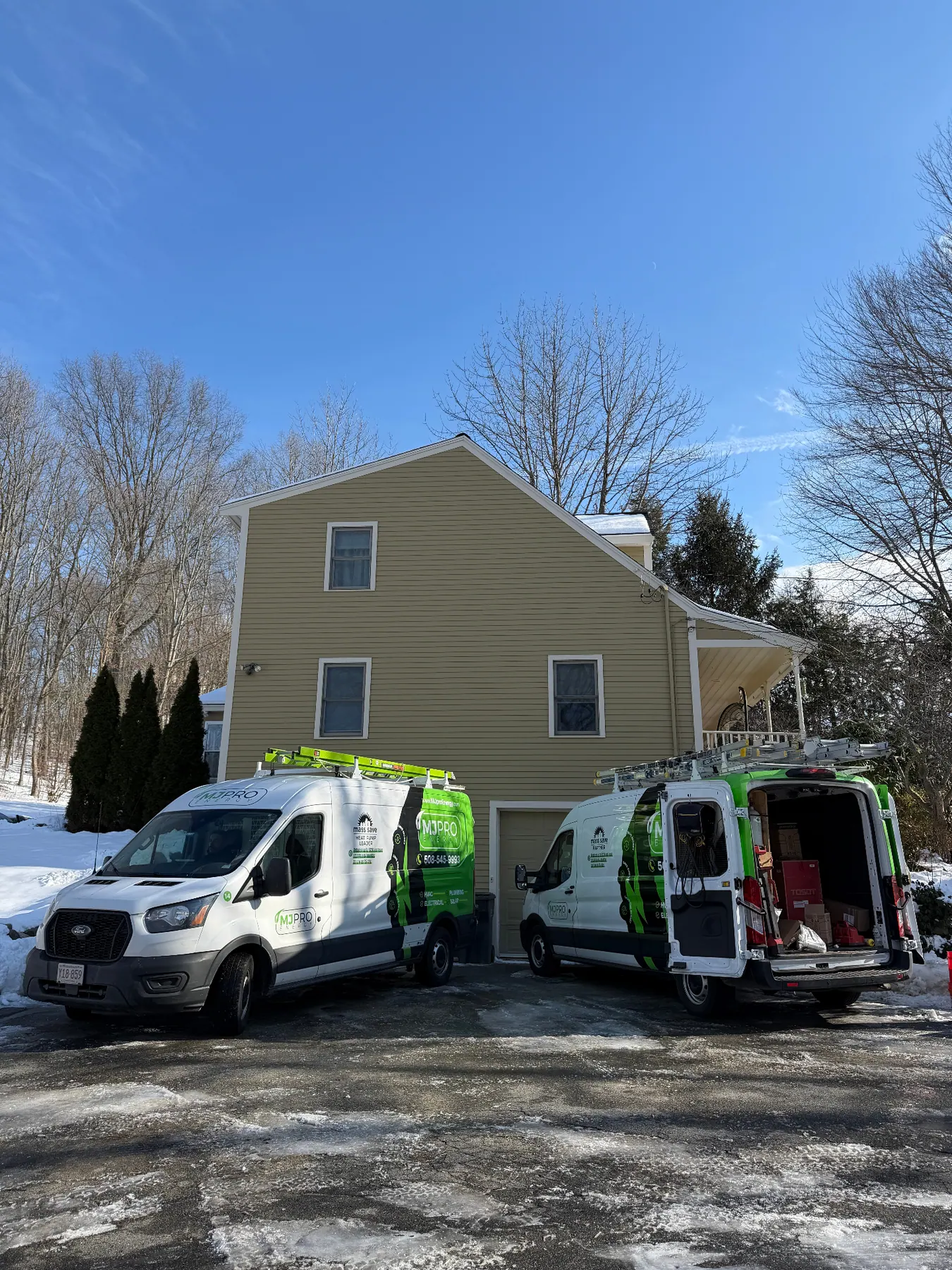 MJ Pro Energy vans parked at a New England home install
